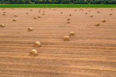 Round bales in a harvested field after summer haymaking seen by a drone