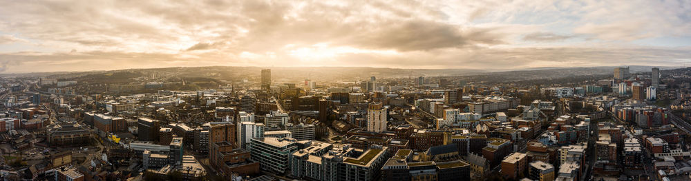 High angle view of city buildings against cloudy sky