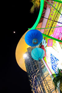 Low angle view of illuminated lanterns hanging against sky at night