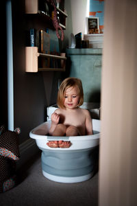 Cute girl taking bath while sitting at home