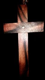 Close-up of cross against black background
