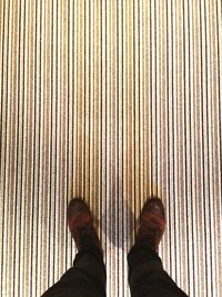 Low section of person standing on tiled floor