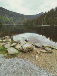 Scenic view of lake by mountain against sky