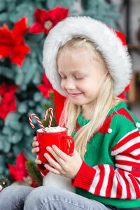 Cute little child girl eating sweet cookies and drinking hot chocolate