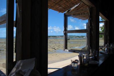 Beach against sky seen through home window