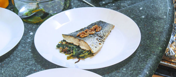 High angle view of fish in plate on marble