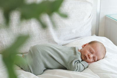 High angle view of baby boy sleeping on bed at home