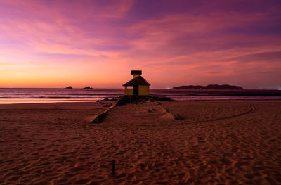 Scenic view of beach against sky during sunset