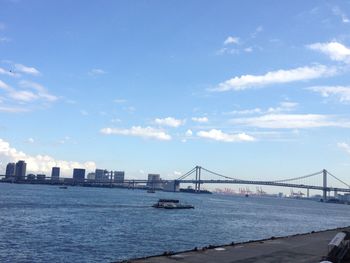 Bridge over river against cloudy sky