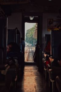 Rear view of man sitting on seat in train