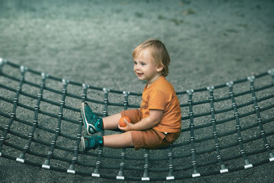 Full length of boy sitting on hammock