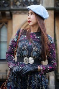 Woman looking away while standing in city