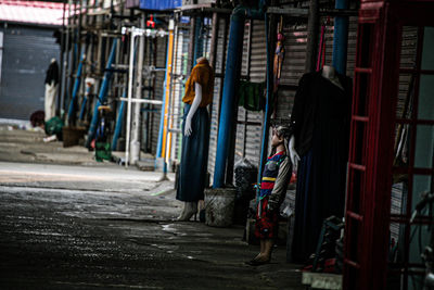 Rear view of woman standing on street in city