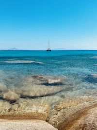 Sailboat sailing on sea against clear sky