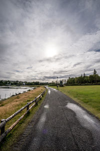 Road by landscape against sky