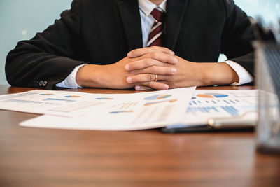 Midsection of man sitting on table