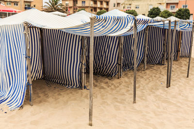 Empty chairs and tables on sand at beach