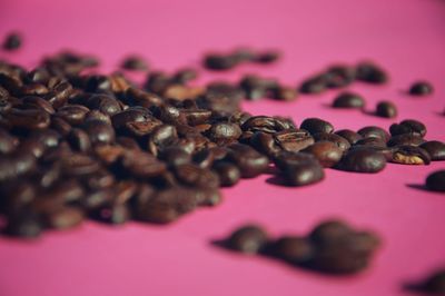 Close-up of roasted coffee beans on pink table