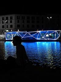 View of illuminated bridge over river at night