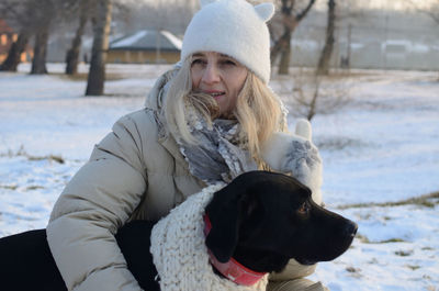 Woman with dog on snow during winter