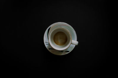 Directly above shot of coffee cup against black background