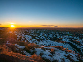 Scenic view of snowcapped landscape against sky during sunset