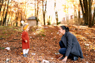 Full length of young woman standing in forest