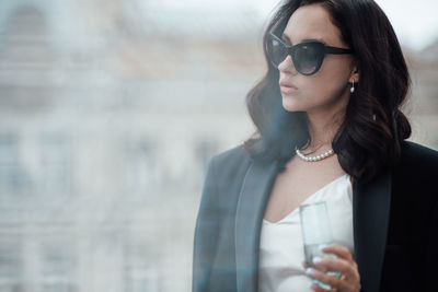 Portrait of a beautiful young woman drinking glass