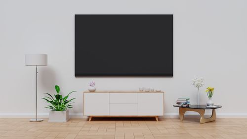 Television set by furniture against wall at home