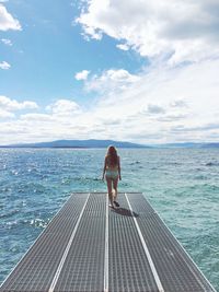 Woman walking down the dock to endless water