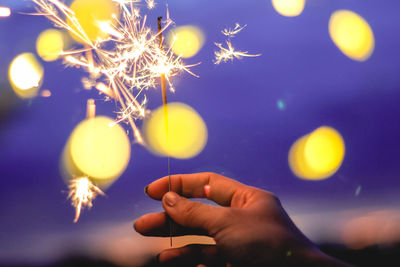 Blurred motion of person hand holding sparkler at night