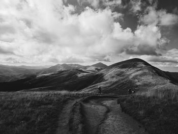 Scenic view of road by mountains against sky