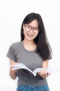 Portrait of smiling young woman against white background