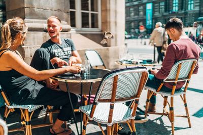 People sitting on table at cafe in city