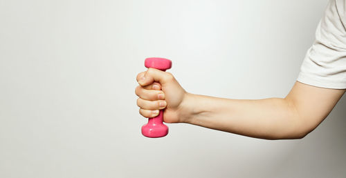 Midsection of woman holding heart shape against white background