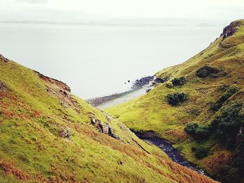 Scenic view of cliff by sea against sky