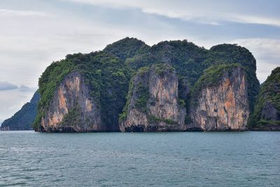 Rock formations by sea against sky