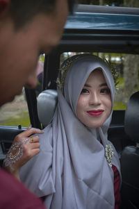 Portrait of a smiling young woman holding camera