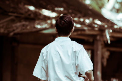 Rear view of man standing at temple against building