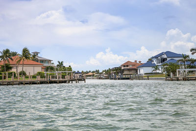 Houses by sea against sky