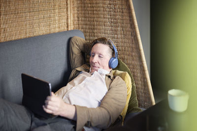 Senior man in headphones using tablet
