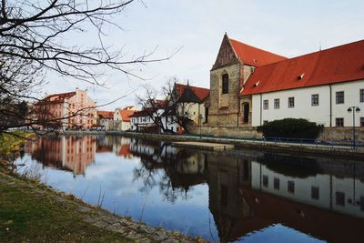 Reflection of houses in river against sky