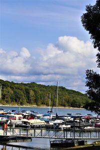 Boats moored at harbor against sky