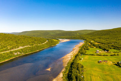 Aerial view of river karasjohka, fields and forest at the border of finland and norway