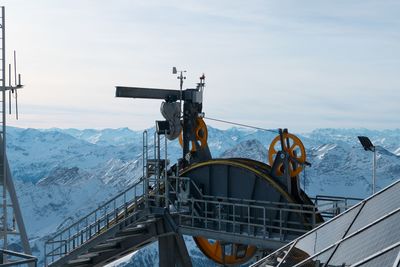 Overhead cable car on landscape against sky