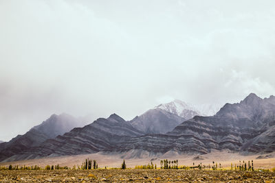 Scenic view of field and mountains against sky