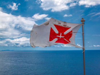 Scenic view of flag against sea and sky