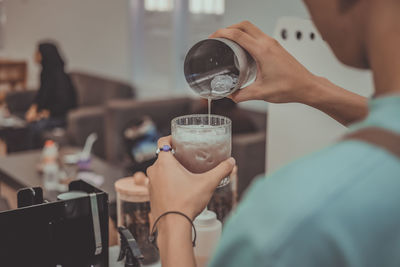 Midsection of woman drinking glass