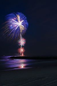 Firework display over sea at night