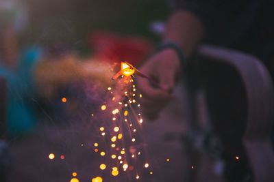 Close-up of sparkler held by man